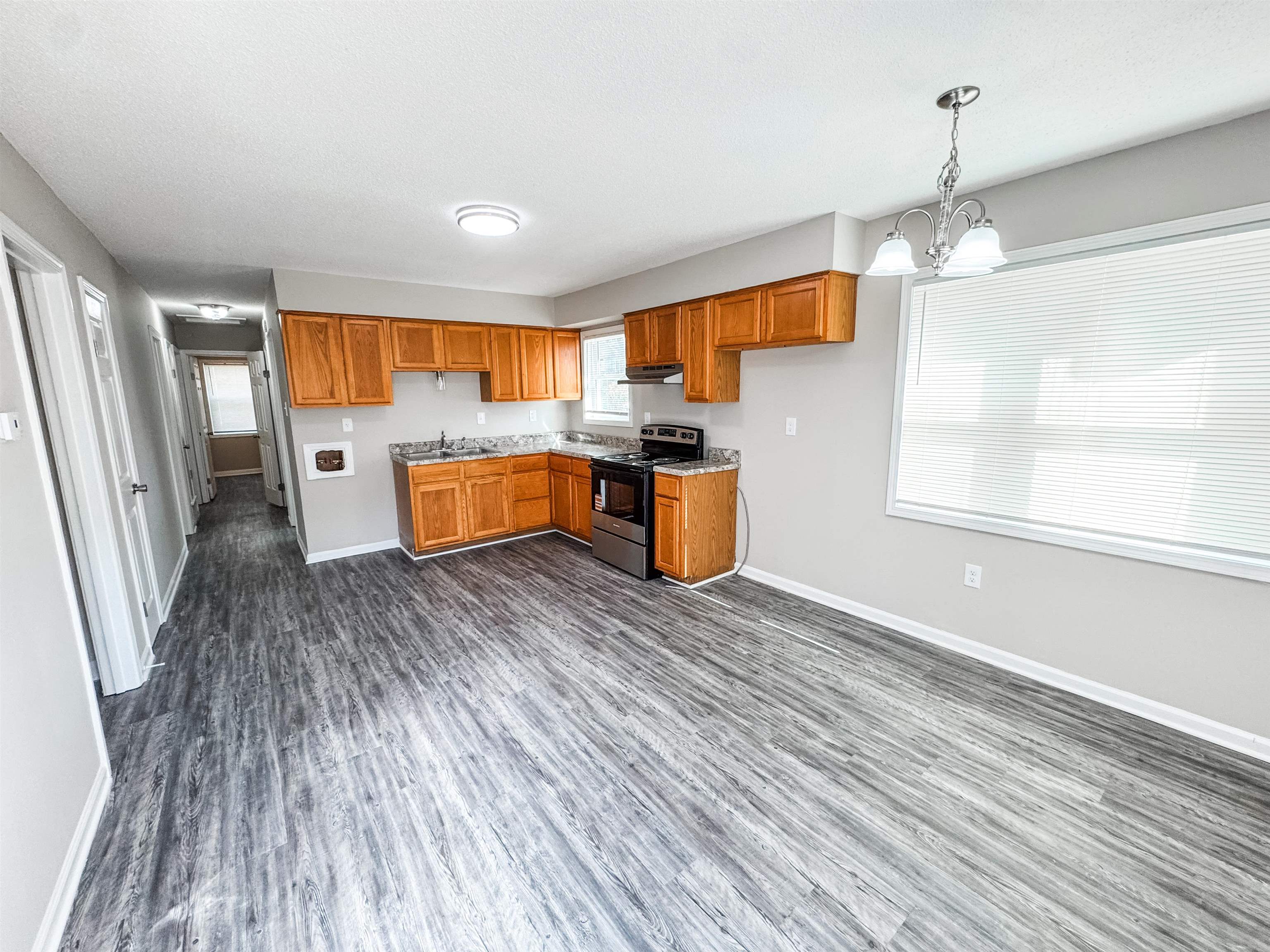 964 Greencliff Road Collierville, TN 38017 - Photo 3 of 7 Kitchen featuring electric stove, hanging light fixtures, brown cabinets, dark wood-style flooring, and a chandelier