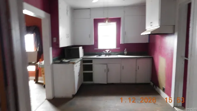 a kitchen with a sink stove and cabinets