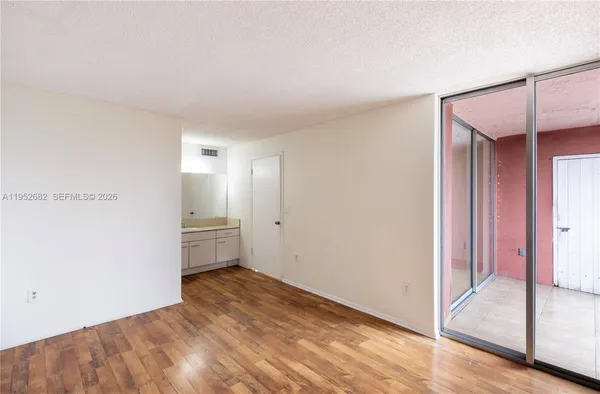 a view of empty room with wooden floor