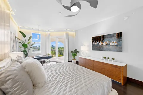a view of a hallway with wooden floor and a bathroom