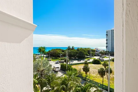 a view of a patio with a dining table and chairs with a small yard