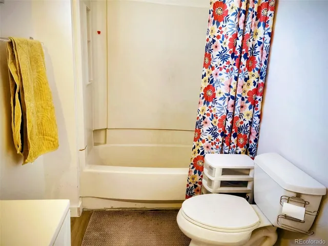 a white toilet sitting next to a bath tub
