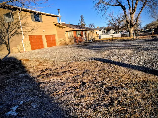 a view of a yard covered with snow in front of house