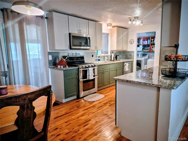 a kitchen with kitchen island granite countertop wooden floors and stainless steel appliances