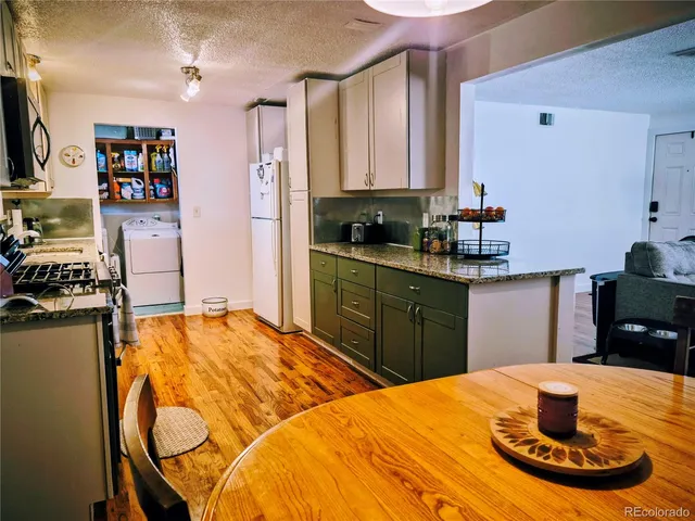 a kitchen with stainless steel appliances granite countertop a sink dishwasher and microwave with wooden floor