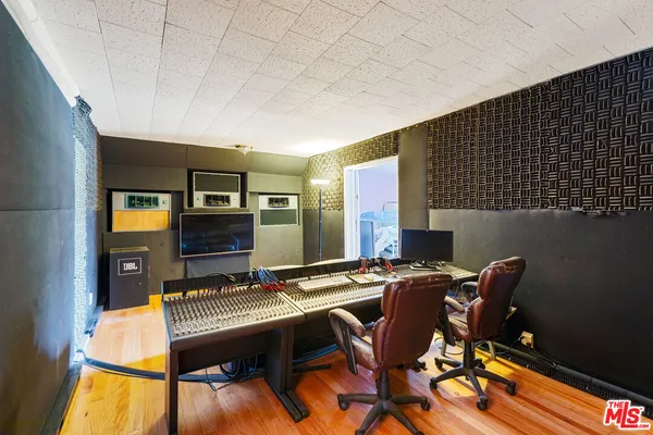 an empty room with wooden floor fireplace and windows