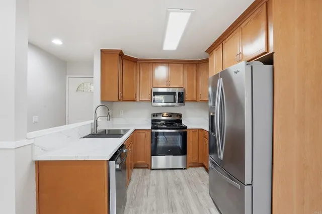 a kitchen with stainless steel appliances granite countertop a refrigerator stove and sink