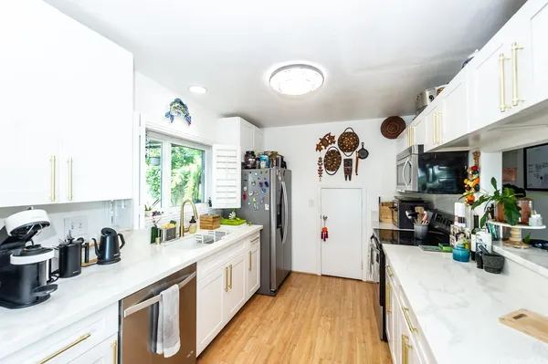 a kitchen with stainless steel appliances lots of counter top space and wooden floor