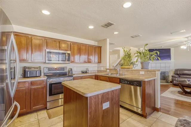 a kitchen that has a lot of cabinets in it and wooden floors