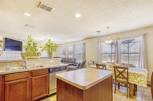 a hall with kitchen island a sink and a large window