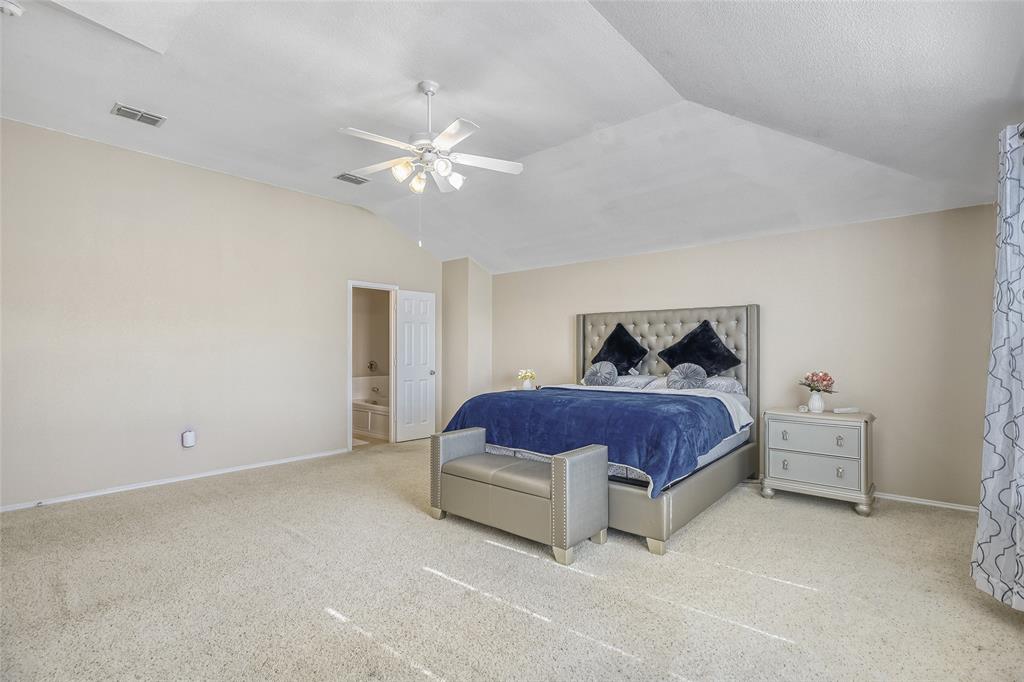 2002 Pin Oak Trail Anna, TX 75409 - Photo 18 of 29 a spacious bedroom with a bed and a chandelier