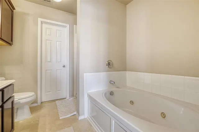 a bathroom with a tub and toilet