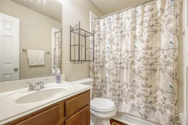 a bathroom with a granite countertop sink a toilet and a mirror