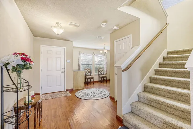 a view of entryway kitchen and hall with wooden floor