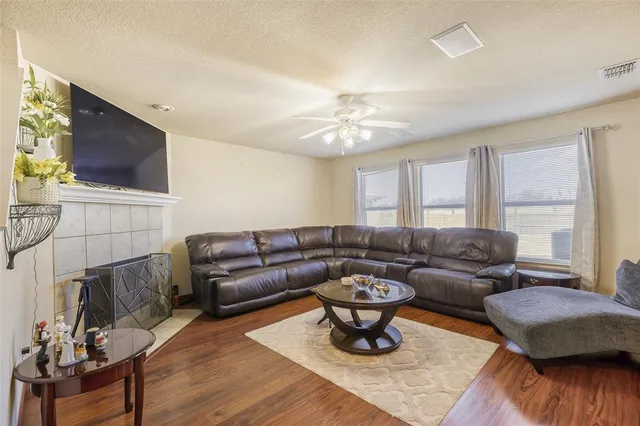 a living room with furniture a flat screen tv and kitchen view
