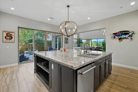 a kitchen with stainless steel appliances granite countertop a stove and a wooden floors