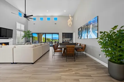 a living room with furniture kitchen view and a flat screen tv