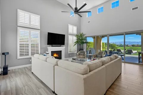 a living room with furniture a flat screen tv and a large window