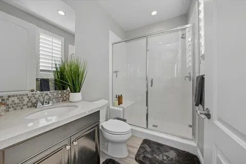 a bathroom with a sink a toilet and shower