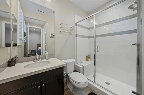 a bathroom with a sink toilet vanity and shower