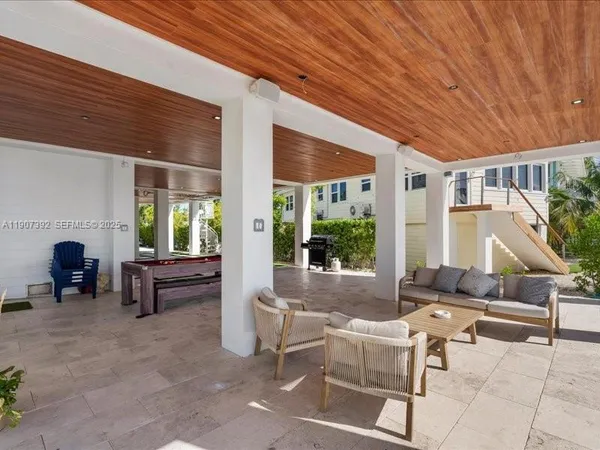 a living room with lots of wooden furniture and chandelier