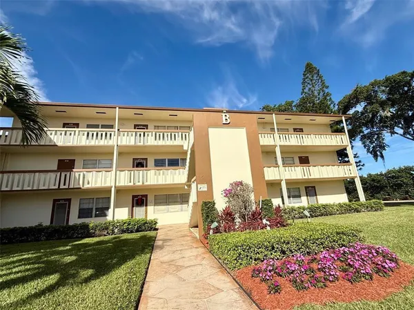 a view of a big building with a big yard and large trees