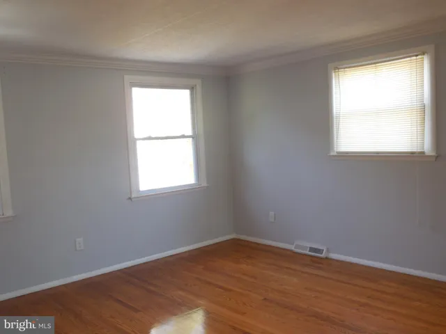 an empty room with wooden floor and a window