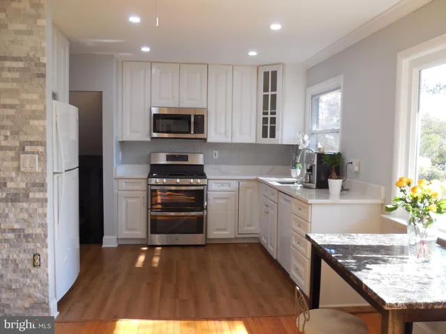 a kitchen with granite countertop a refrigerator stove and microwave