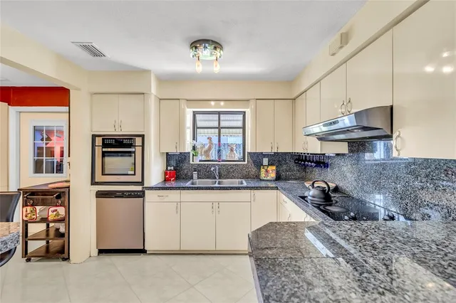 a kitchen with stainless steel appliances granite countertop a sink and cabinets