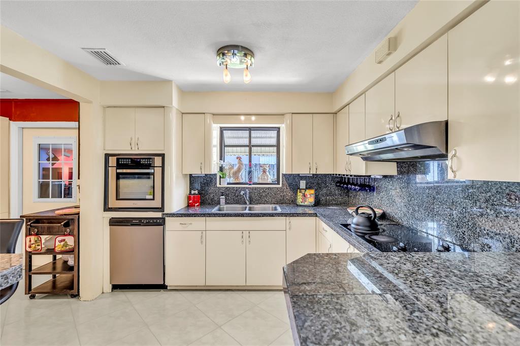 1961 Northeast 31st Street Lighthouse Point, FL 33064 - Photo 17 of 31 a kitchen with stainless steel appliances granite countertop a sink stove and refrigerator