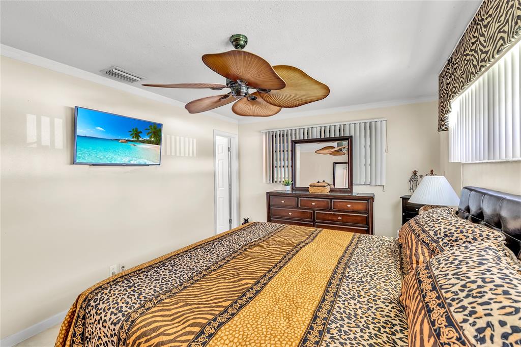 1961 Northeast 31st Street Lighthouse Point, FL 33064 - Photo 27 of 31 a bedroom with a bed and a chandelier