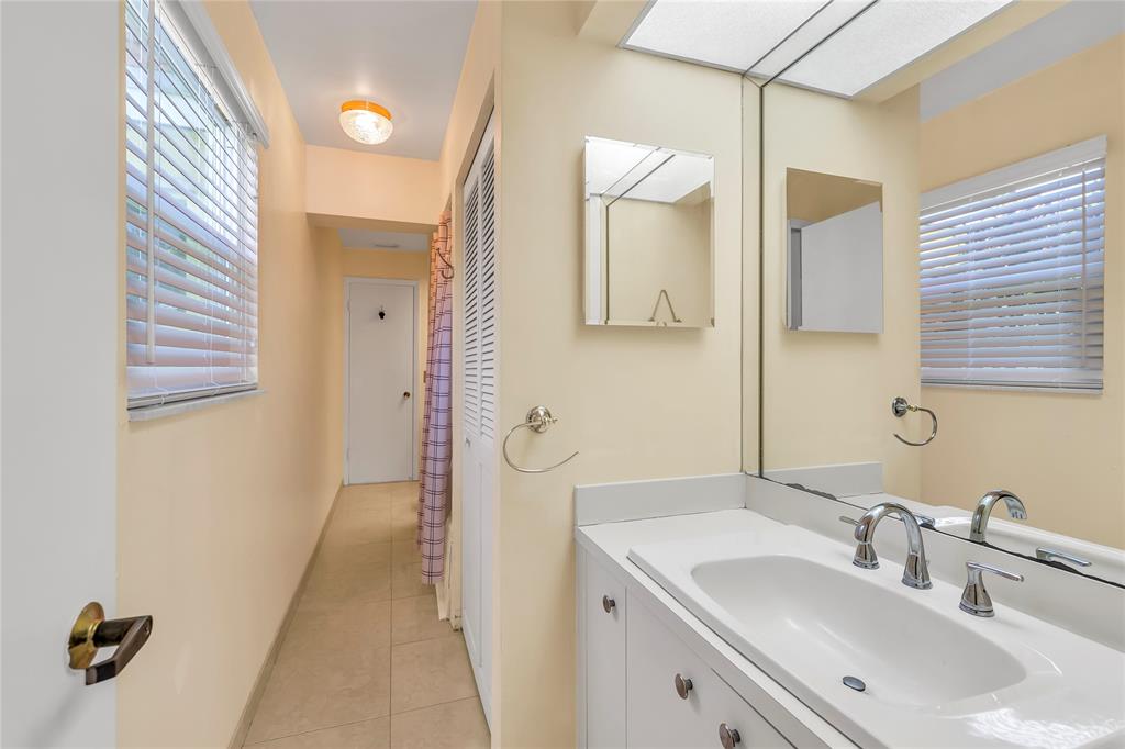 1961 Northeast 31st Street Lighthouse Point, FL 33064 - Photo 29 of 31 a bathroom with a sink and a mirror
