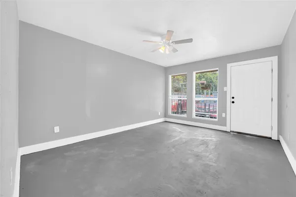 an empty room with chandelier fan