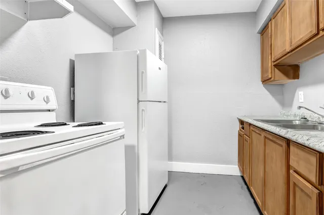 a kitchen with a refrigerator sink stove and cabinets