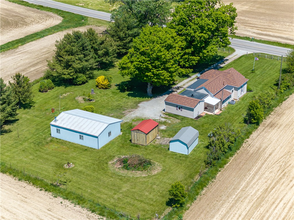 1217 Jasper Road Xenia, OH 45385 - Photo 13 of 62 An aerial perspective reveals a rural home nestled amidst expansive green surroundings and agricultural fields.