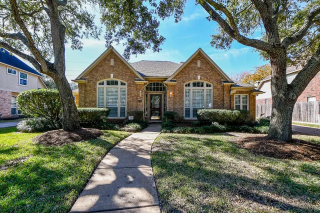 a front view of a house with yard and green space
