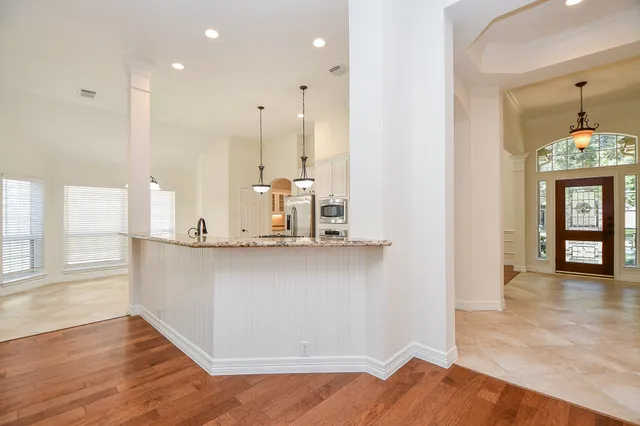 wooden floor in an empty room with a fireplace and a window