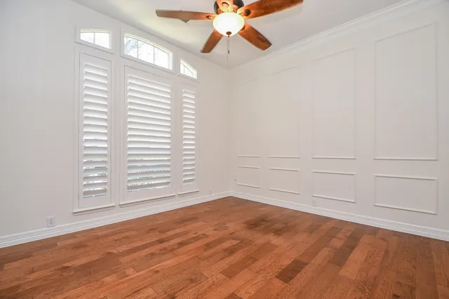 a view of an empty room with a window and wooden floor