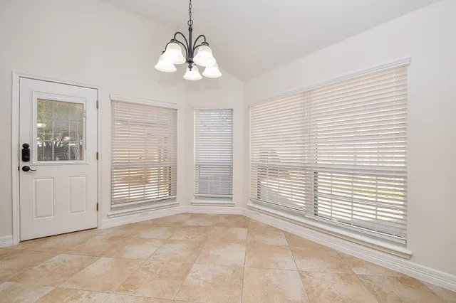 a view of kitchen with granite countertop cabinets and refrigerator