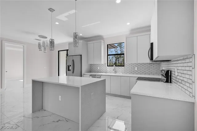 a kitchen with a sink a stove a refrigerator and white cabinets