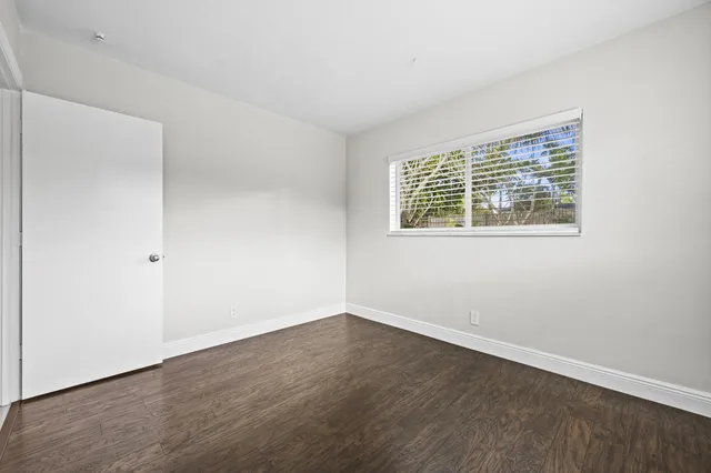a view of an empty room with wooden floor