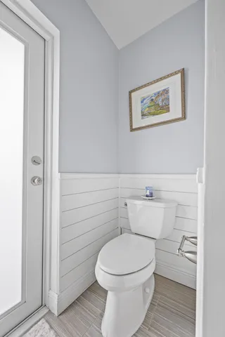 a view of an empty room with wooden floor and a ceiling fan