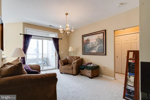 a living room with furniture a chandelier and a bookshelf