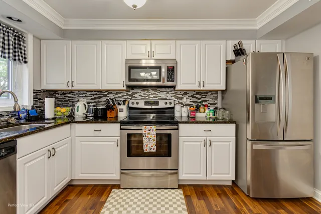 a kitchen with white cabinets and stainless steel appliances