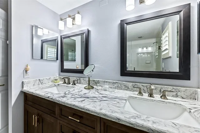 a bathroom with double vanity sinks and a mirror