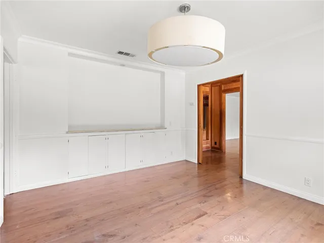 an empty room with wooden floor and natural light