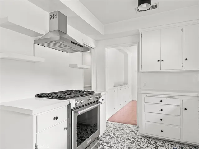 a kitchen with white cabinets and appliances