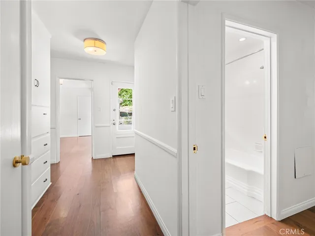 a view of a hallway with wooden floor and closet