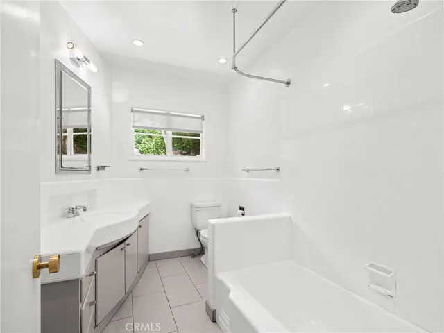 a spacious bathroom with a bathtub sink and mirror