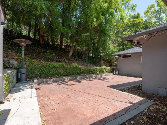 a patio with table and chairs and potted plants